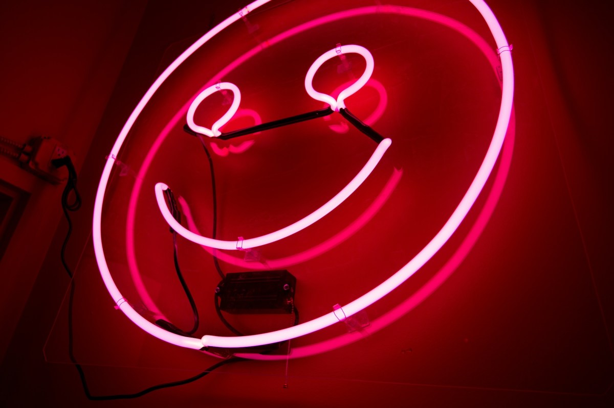 Pink neon of a smiley face. Creative health