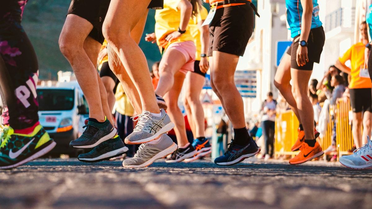 A photograph of a group of runners' legs and feet as they limber up for a race, showing them bouncing, jogging, jumping and stretching. The photograph illustrates ArtsHub's weekly On the move column of Australian arts sector appointments.