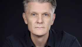 Rhett Davis, a profile photo of a man with short grey hair. Author of Arborescence.