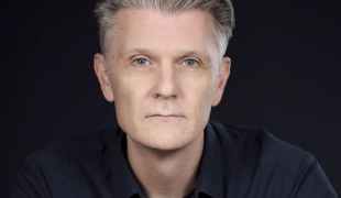 Rhett Davis, a profile photo of a man with short grey hair. Author of Arborescence.