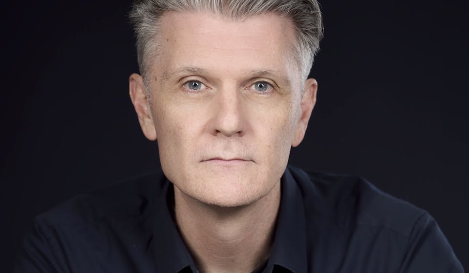 Rhett Davis, a profile photo of a man with short grey hair. Author of Arborescence.