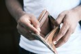 man in white t-shirt holding open wallet with no money. Poverty line artists