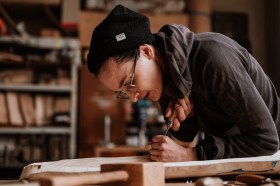 Woman in studio working on wood makers bench. Homo Faber.