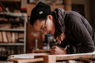 Woman in studio working on wood makers bench. Homo Faber.