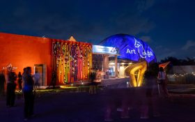 Art&Bali buildings lit up in colourful lights at night.