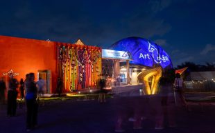 Art&Bali buildings lit up in colourful lights at night.