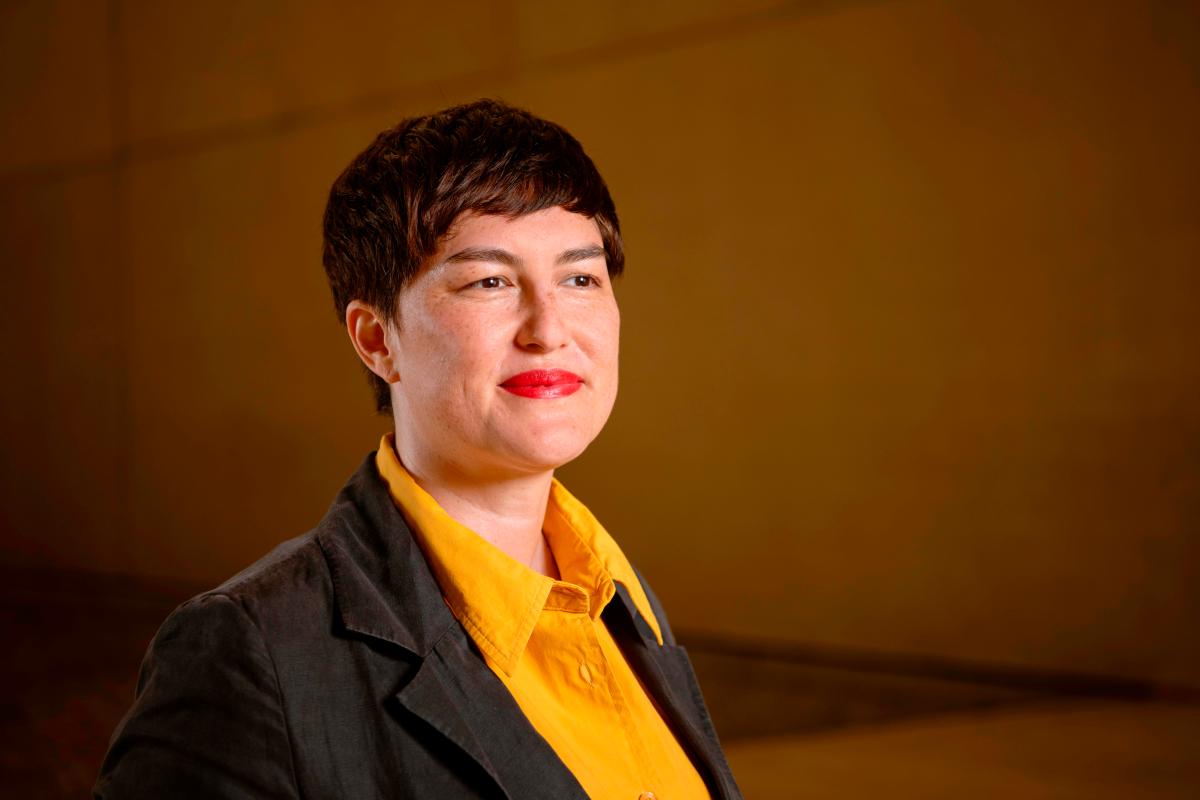 photo of woman with short dark hair and yellow shirt. Ellie Buttrose