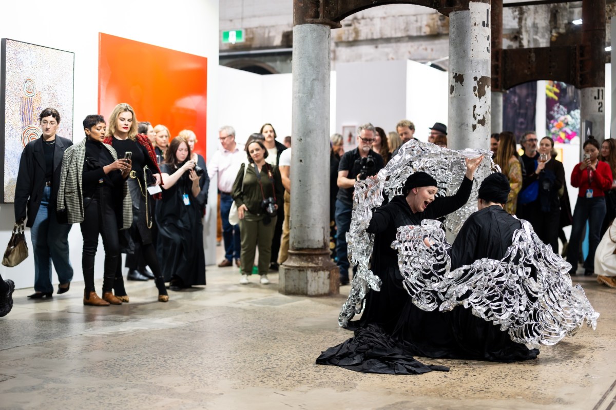 People dressed in black with a prop doing a performance at an art fair. Sydney Contemporary
