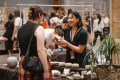 A makers market with a woman selling a ceramic pot to a buyer. Sydney Craft Week