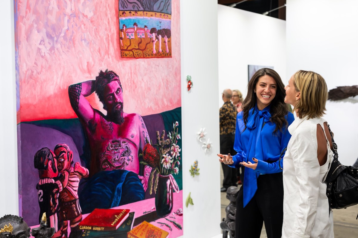 Two women looking at art and chatting at an art fair. Sydney Contemporary.