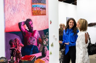 Two women looking at art and chatting at an art fair. Sydney Contemporary.