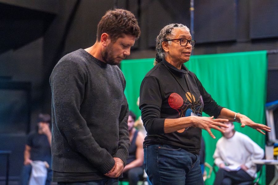 Trawlwoolway, Pakana/Palawa playwright Nathan Maynard and director Rachael Maza in a development of ILBIJERRI's work in progress, 'The Line'. Maynard listens as Maza speaks and gestures; her hands are animated and splayed.