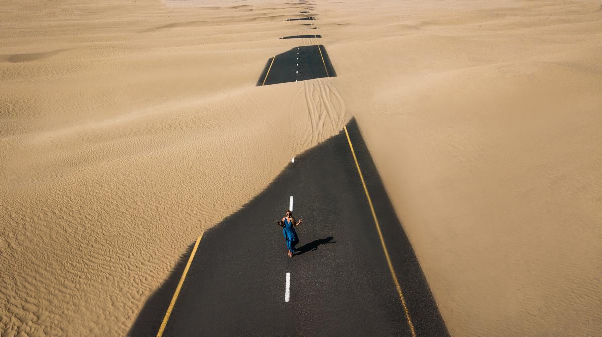 Image of a road with a single person walking down it and it is covered with sand. Superannuation