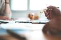 Corporate arts partnership dilemmas: a close up of someone's hand holding a gold pen over a desk about to sign a contract.