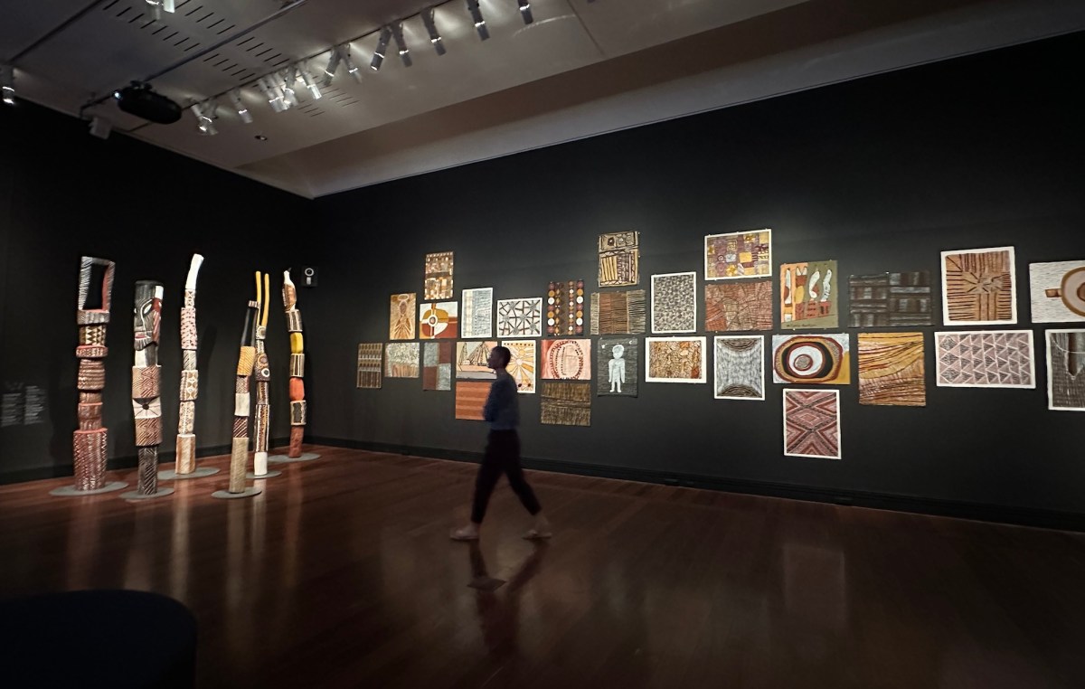 Gallery view of traditional Tiwi Islands and Aboriginal art on black walls. Tarnanthi