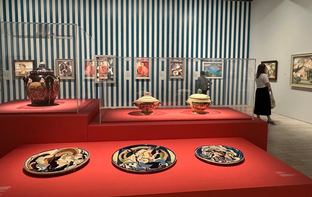 Gallery view with blue stripe wallpaper and red display case full of cubist ceramics. Dangerously Modern.