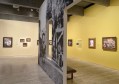 Gallery view with painted yellow walls, historic painting and black and white wall vinyls from photographs. Dangerously Modern.