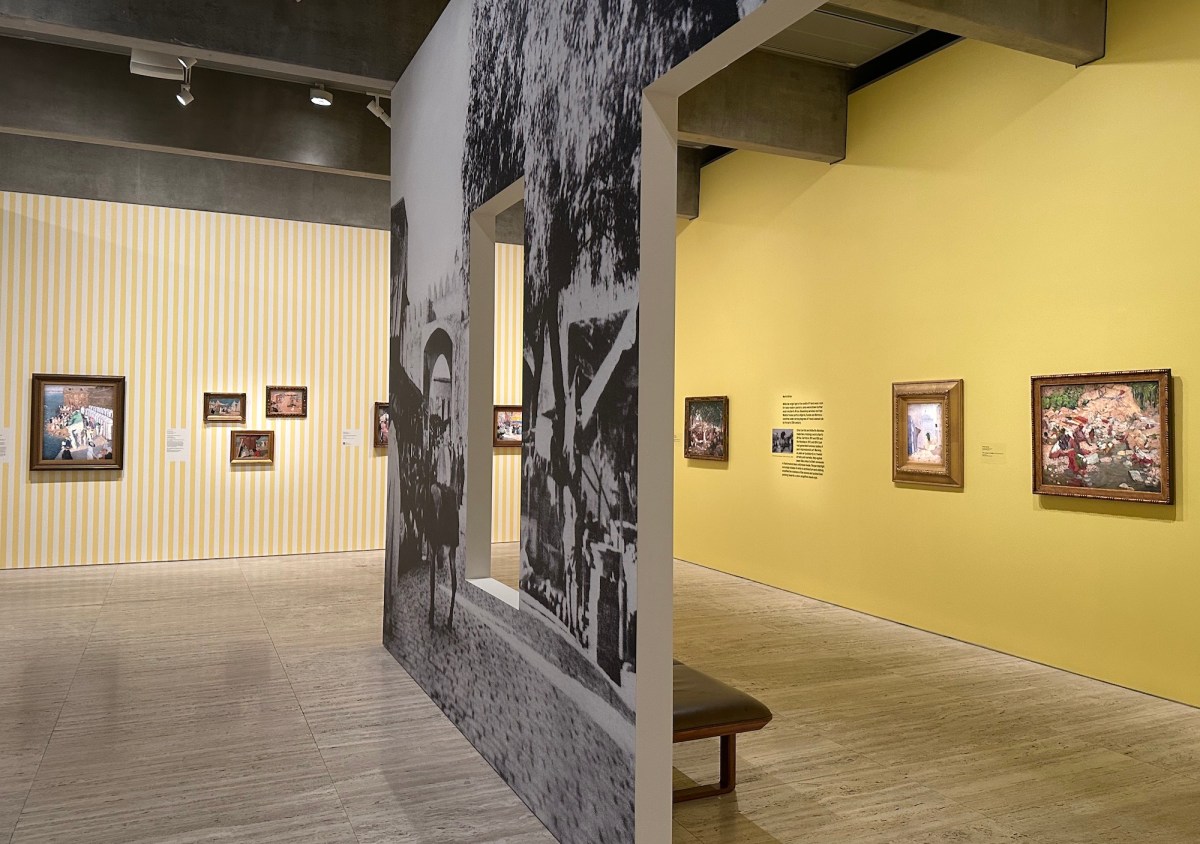 Gallery view with painted yellow walls, historic painting and black and white wall vinyls from photographs. Dangerously Modern.