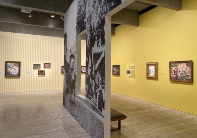 Gallery view with painted yellow walls, historic painting and black and white wall vinyls from photographs. Dangerously Modern.