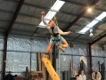 Man suspended from ceiling from ropes in balance with a log. The Unconformity, Luke George