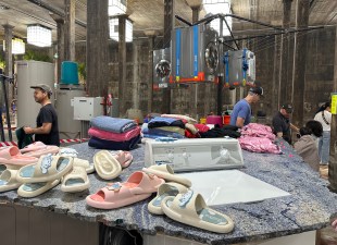 Gallery installation with dryers and recycled slippers in basement environment. Mike Hewson.