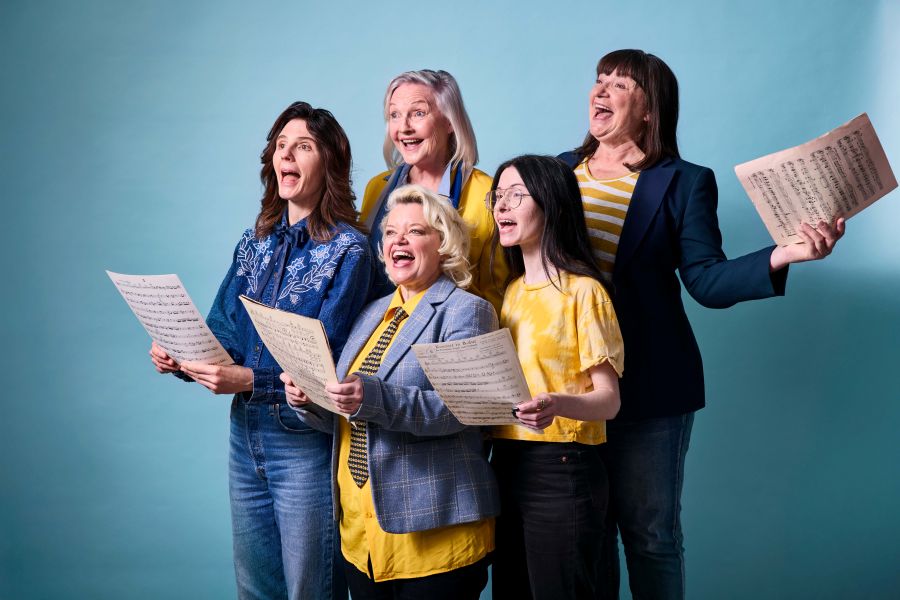 Publicity image for State Theatre Company South Australia's season 2026 production, 'The Heartbreak Choir'. Five women, varying in ages and including one Asian-Australian woman, hold musical scores and sing.