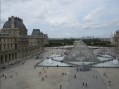 Exterior view of historical building and forecourt with people. The Louvre