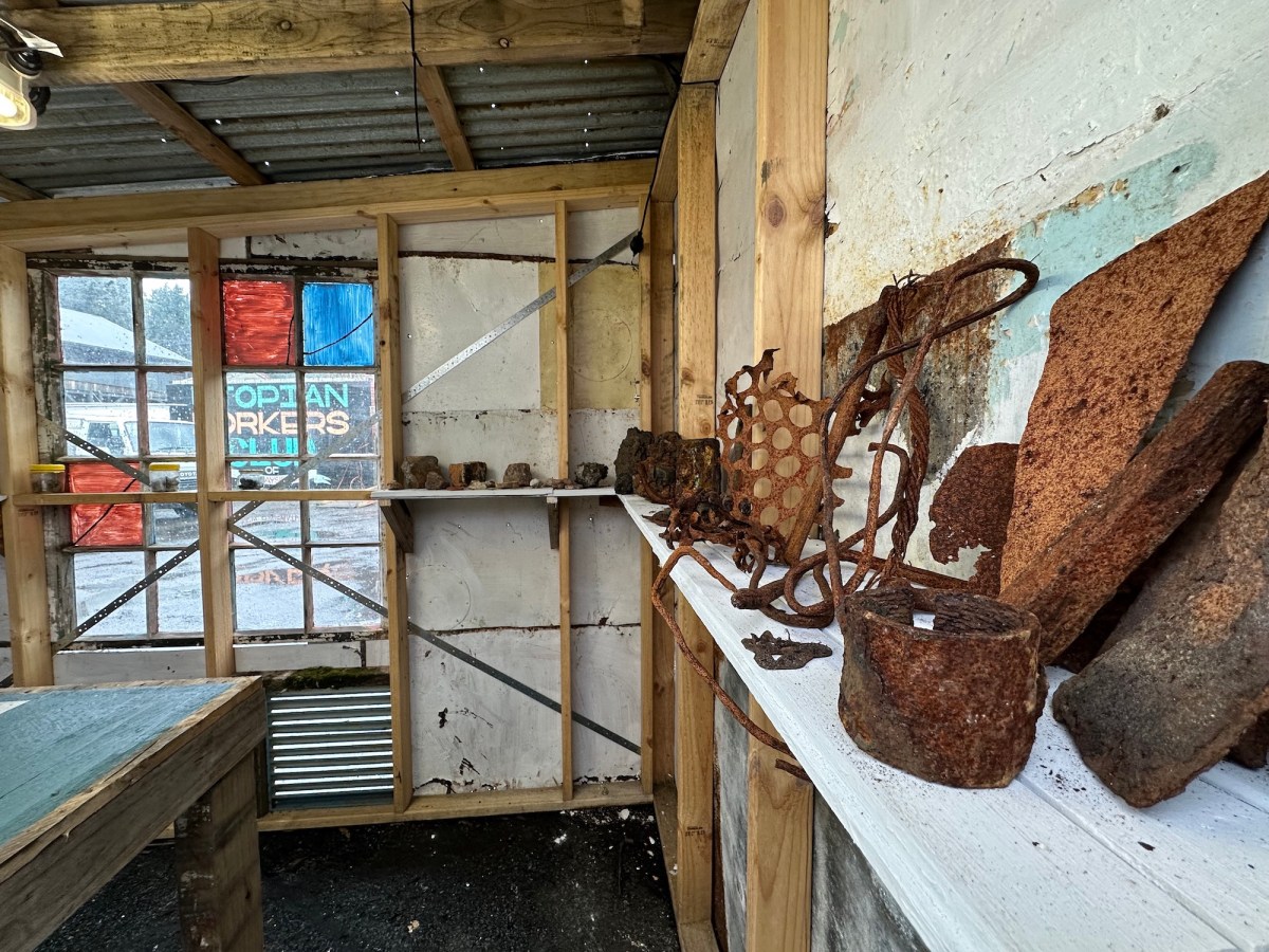rusted metal found objects displayed on a shelf. The Unconformity