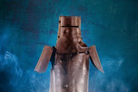 A publicity image for Victorian Opera's upcoming production, a revival of Reg Livermore's 'Ned Kelly - The Musical', to be staged as part of the company.s 2026 season. Ned Kelly's iconic helmet and armour, beaten out of ploughshares, is photographed against a blue background.