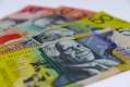 Arts funding: four Australian bank notes laid on a table. Two twenty dollar bills appear at the back covered partially by two fifty dollar note on top.