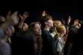 access and inclusion: a photo of a group of young people in the their late teens and early twenties standing in a crowd watching a music concert against a black background.