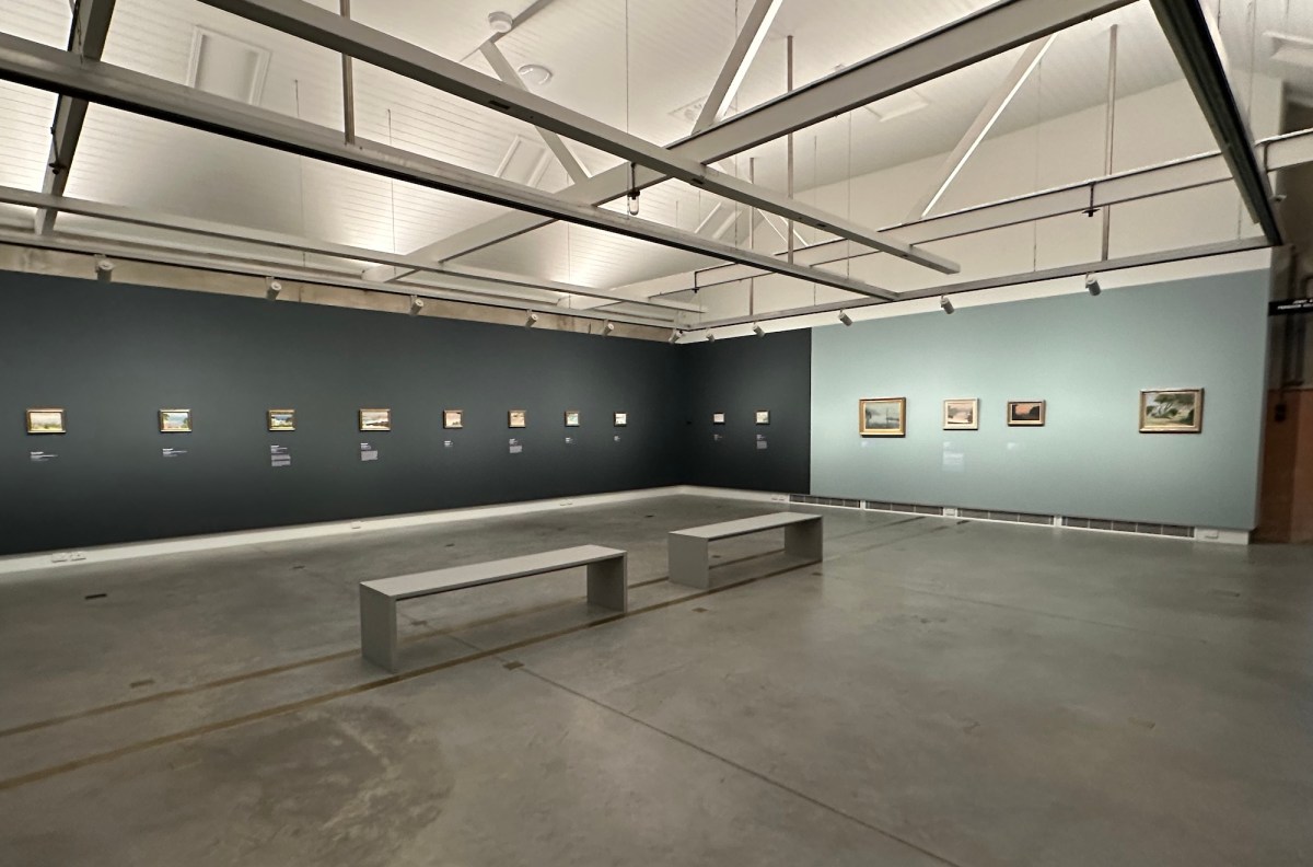 Gallery setting with small paintings on walls in blue tones. Mirra Whale, Clarice Beckett