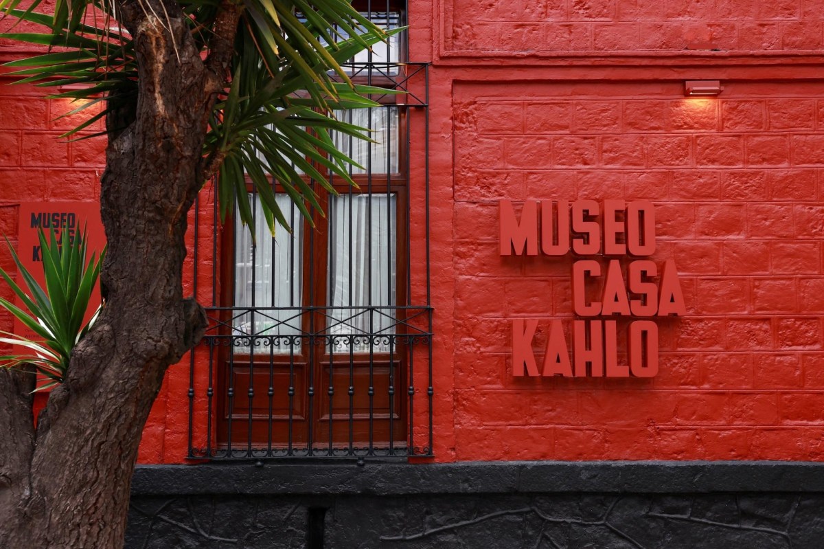 Red brick facade of a museum with writing saying Museo Casa Kahlo. Frida Kahlo
