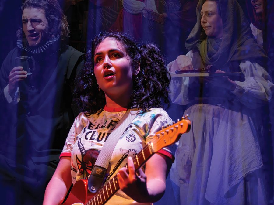 Promotional image for Brown’s Mart Arts’ 2026 production, ‘Genius’. A young woman holds a guitar and sings; people in medieval clothing stand behind her, a scrim making them seem ghostly or insubstantial.