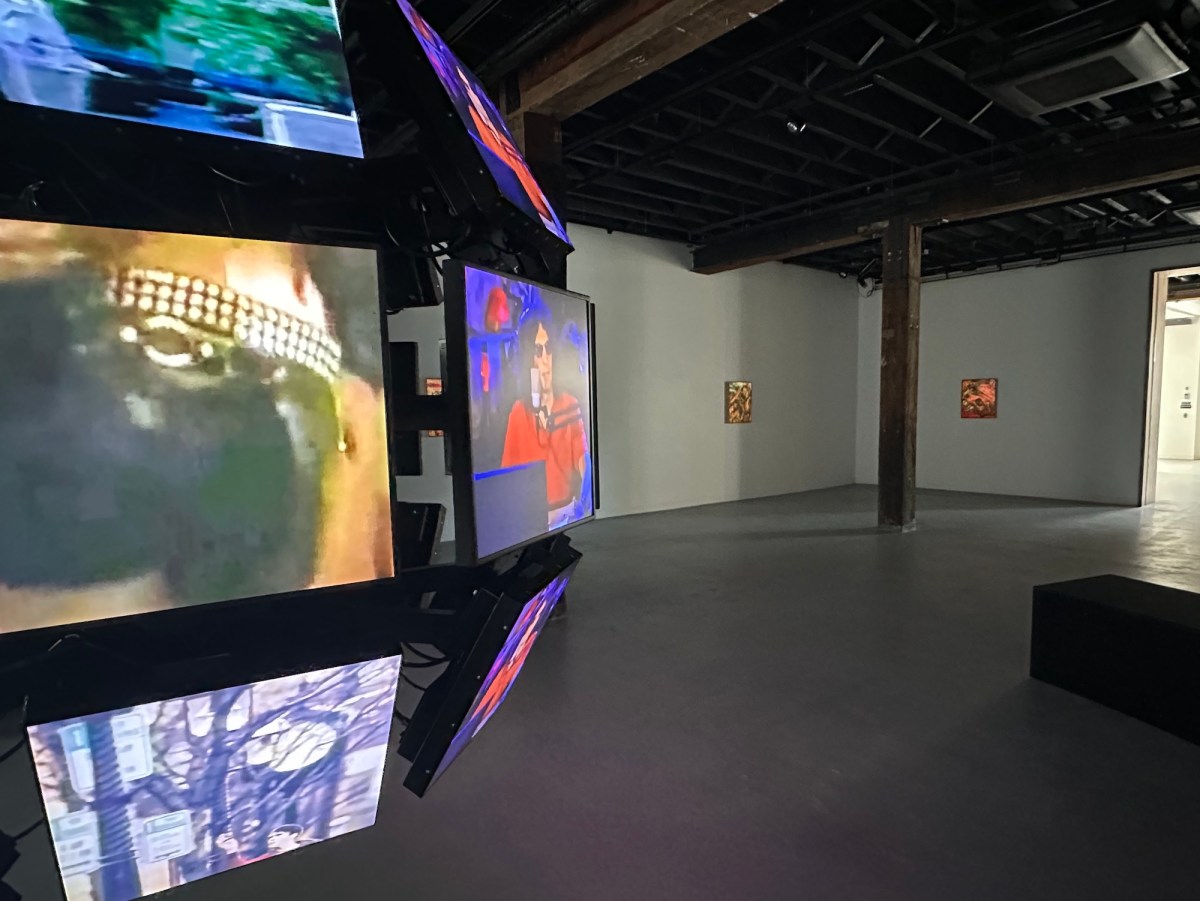 Gallery view of a video installation of televisions screens in an orb and paintings in background. AI art