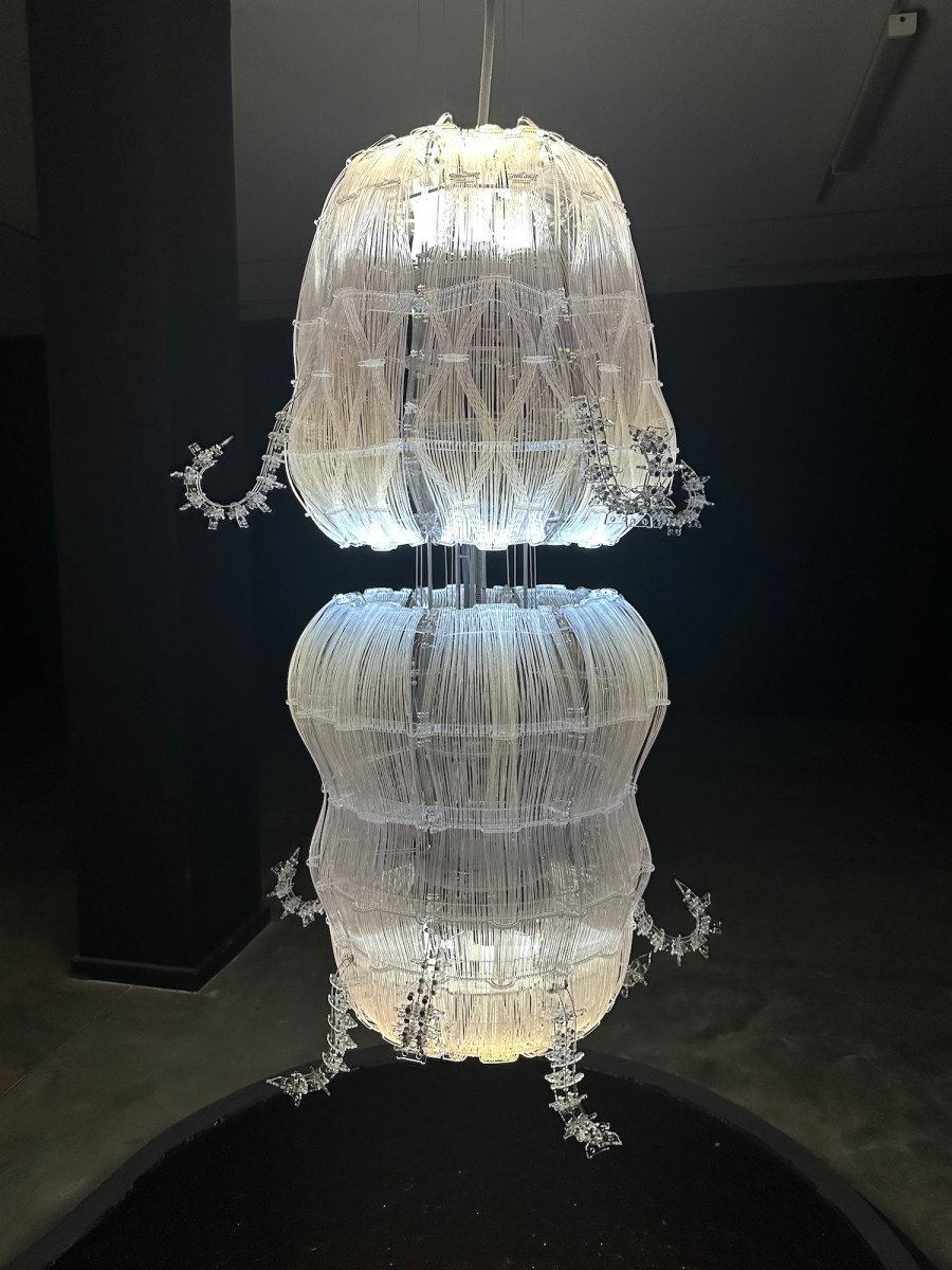 white sea like form in white in a dark room - sculpture. AI