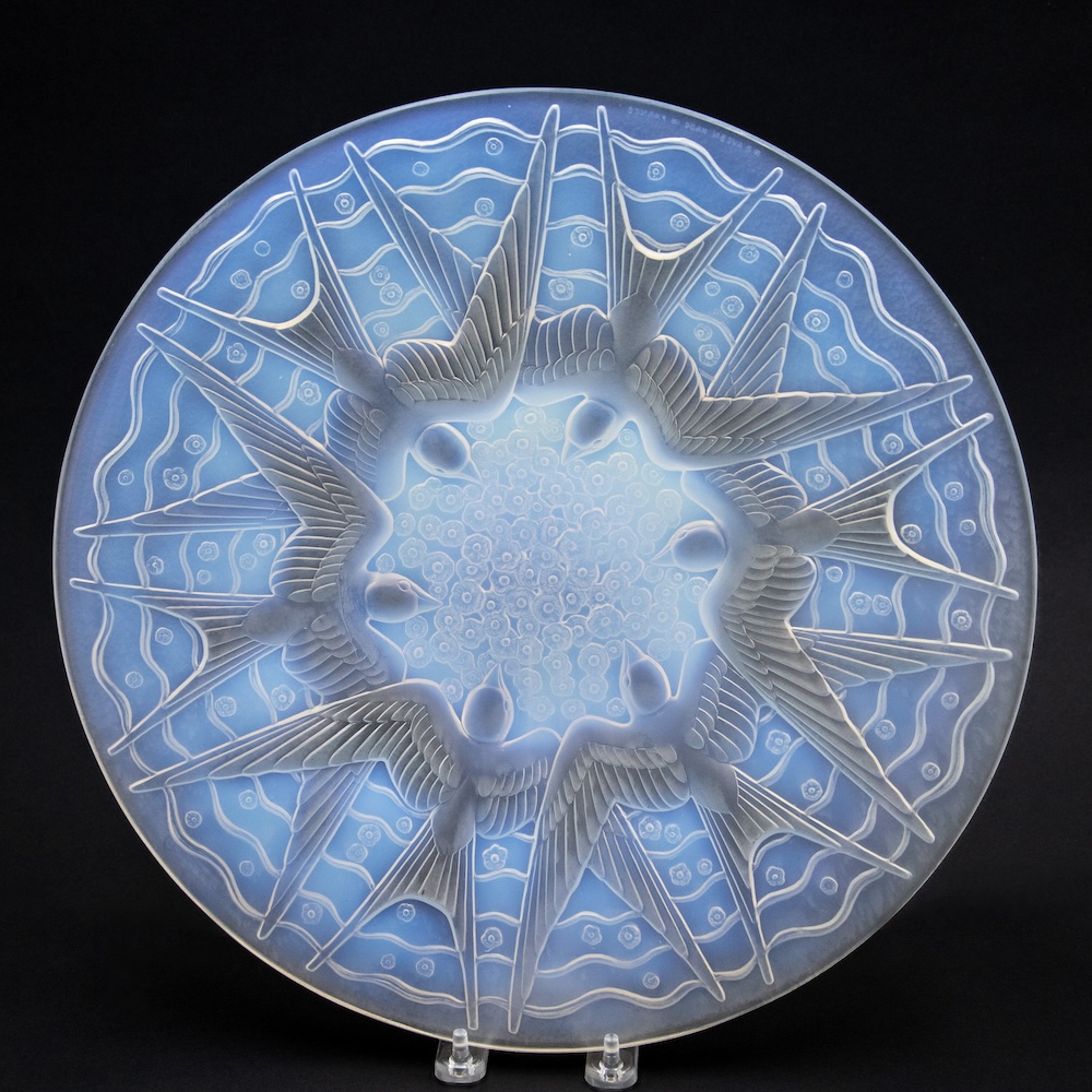 overhead view of a glass plate with carved Art Deco design of swallows.