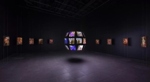 Exhibition gallery view of video work on a floating globe in darkened space. cool exhibitions