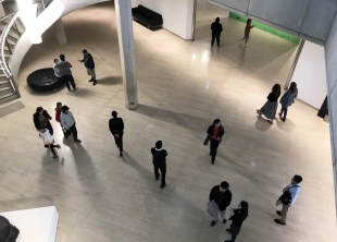 arts philanthropy: a bird's eye view over the atrium entry space of a large gallery showing around 15 gallery visitors moving around the space.