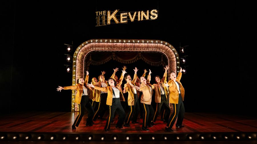 The 11 Kevins perform in 'Tivoli Lovely', WAAPA's new Australian musical by Eddie Perfect. Eleven performers in golden jackets and matching black pants with gold piping sing with their arms stretched out above them.