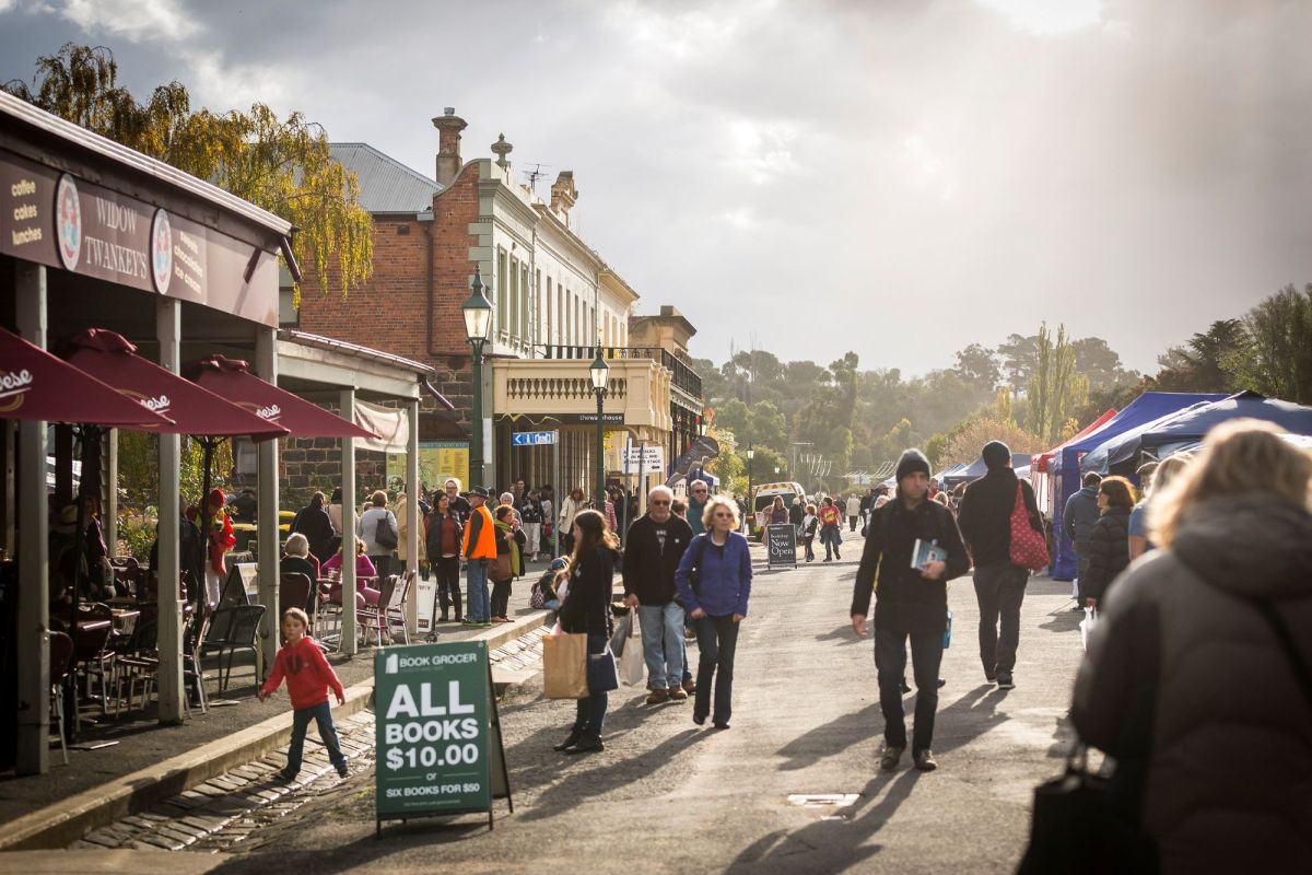 A state-wide Victorian Literature Strategy will be developed as part of Creative State 2028. Pictured is the Fraser Street Book Bazaar at Clunes Booktown Festival., showing people wandering down street, which has been closed to traffic, so people can buy books.