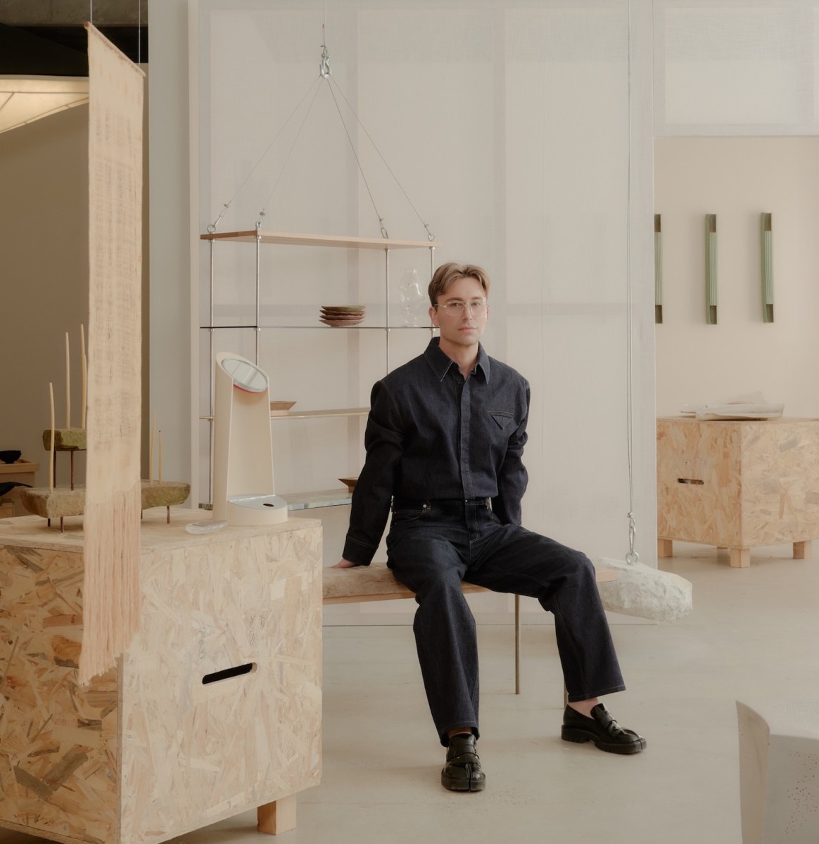 Man dressed in black sitting with exhibition with strong design feel