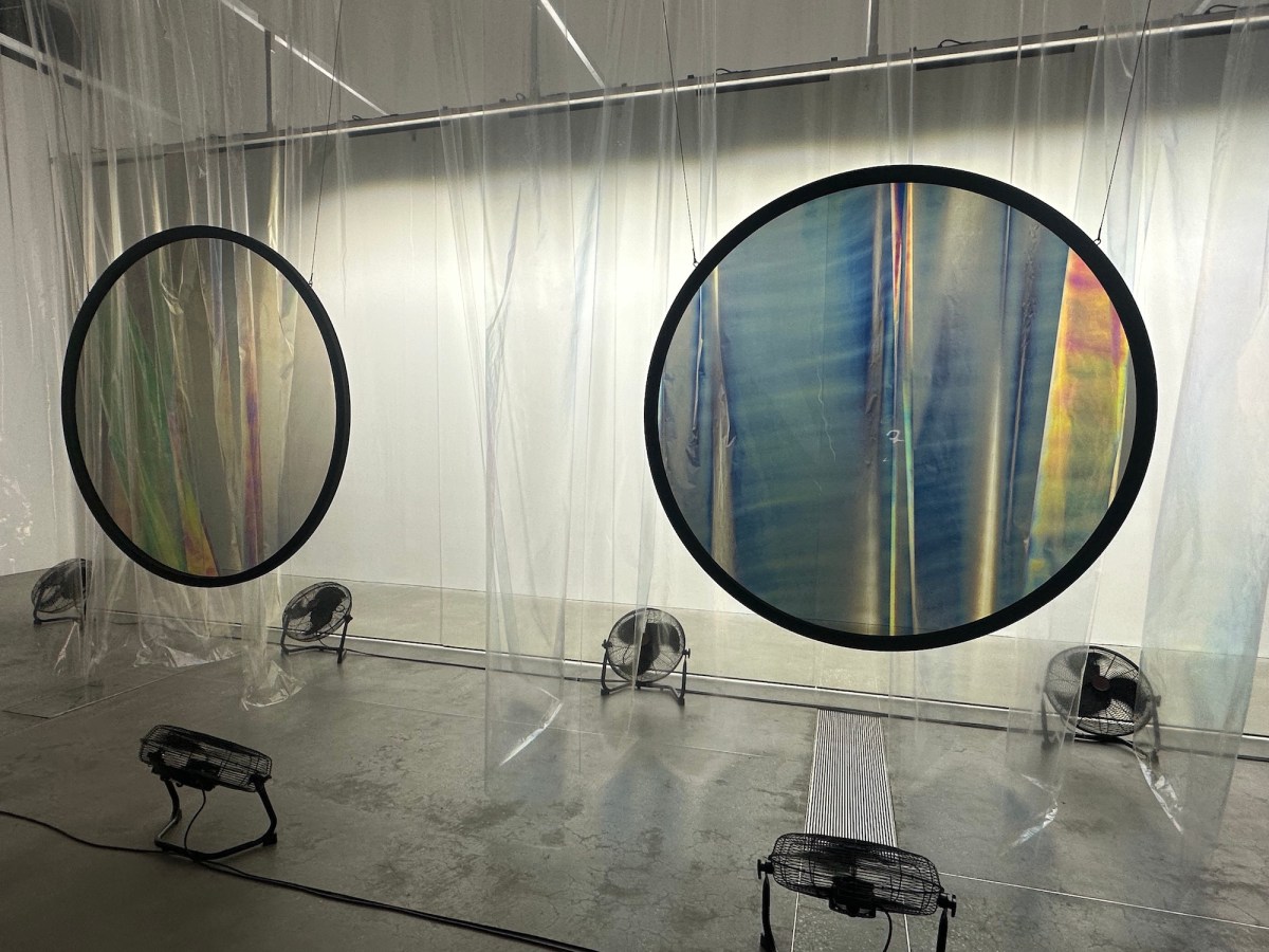 Gallery view with kinetic sculpture with fans, plastic curtain and polarising filters. Olafur Eliasson