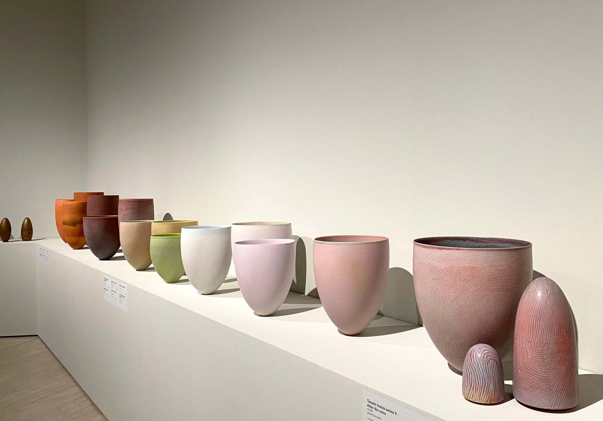 Pippin Drysdale: Infinite Terrain Major Retrospective exhibition 2025: a photo of pale pink, white, pale green and pale yellow coloured large ceramic vessels displayed on a white shelf against a white wall in a contemporary gallery space.