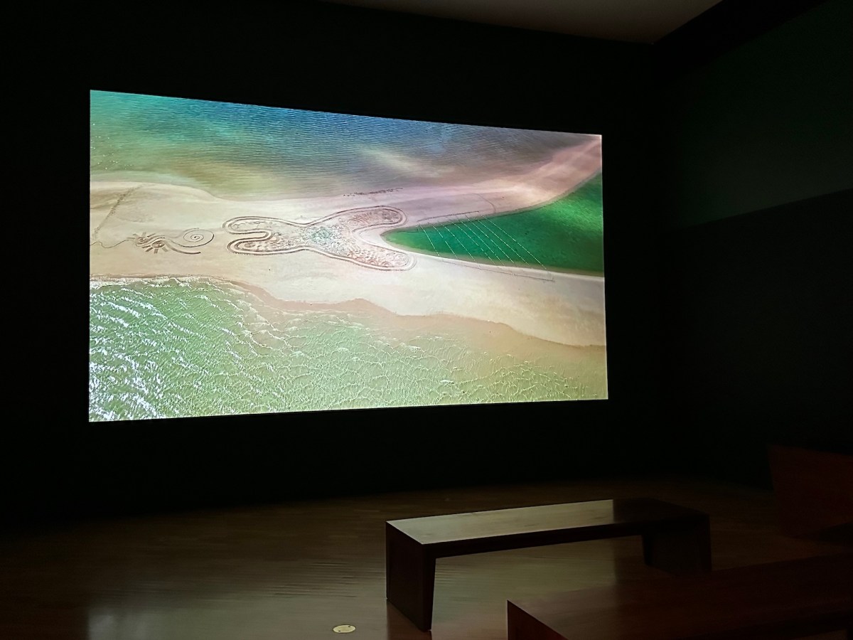 Video view of a remote beach with aboriginal designs on sand. Tony Albert's Indigenous Triennial.