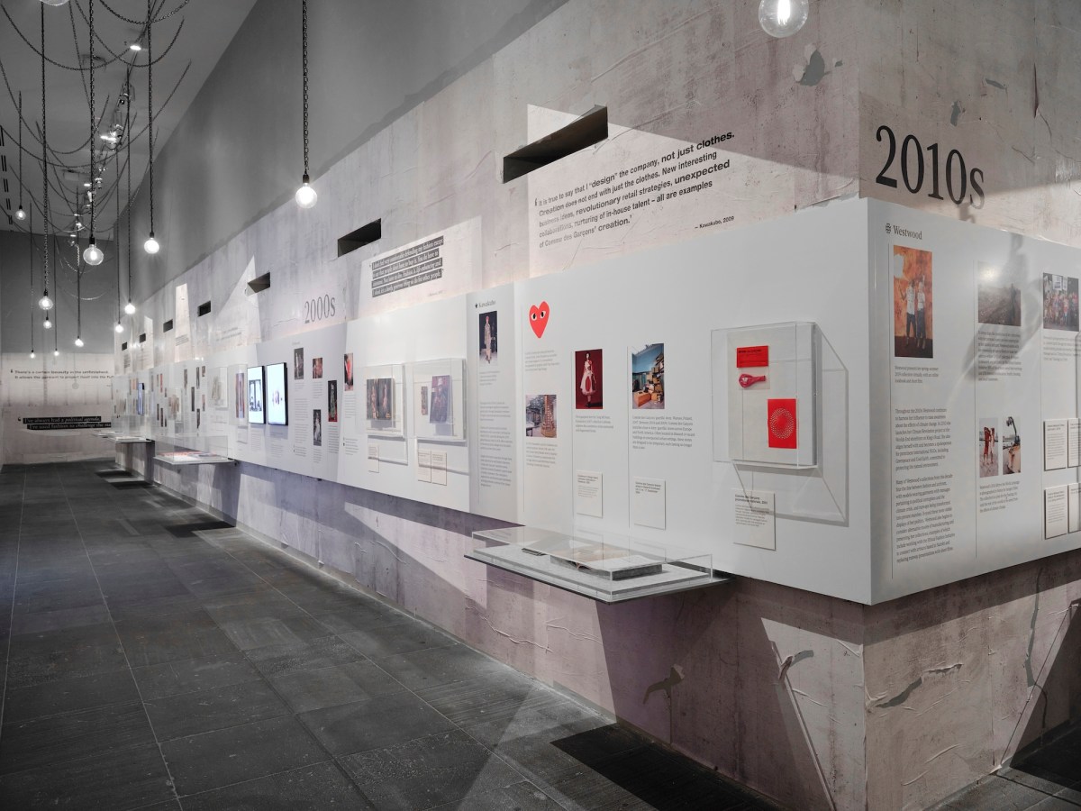 Exhibition display of a timeline and archival material. Westwood / Kawakubo