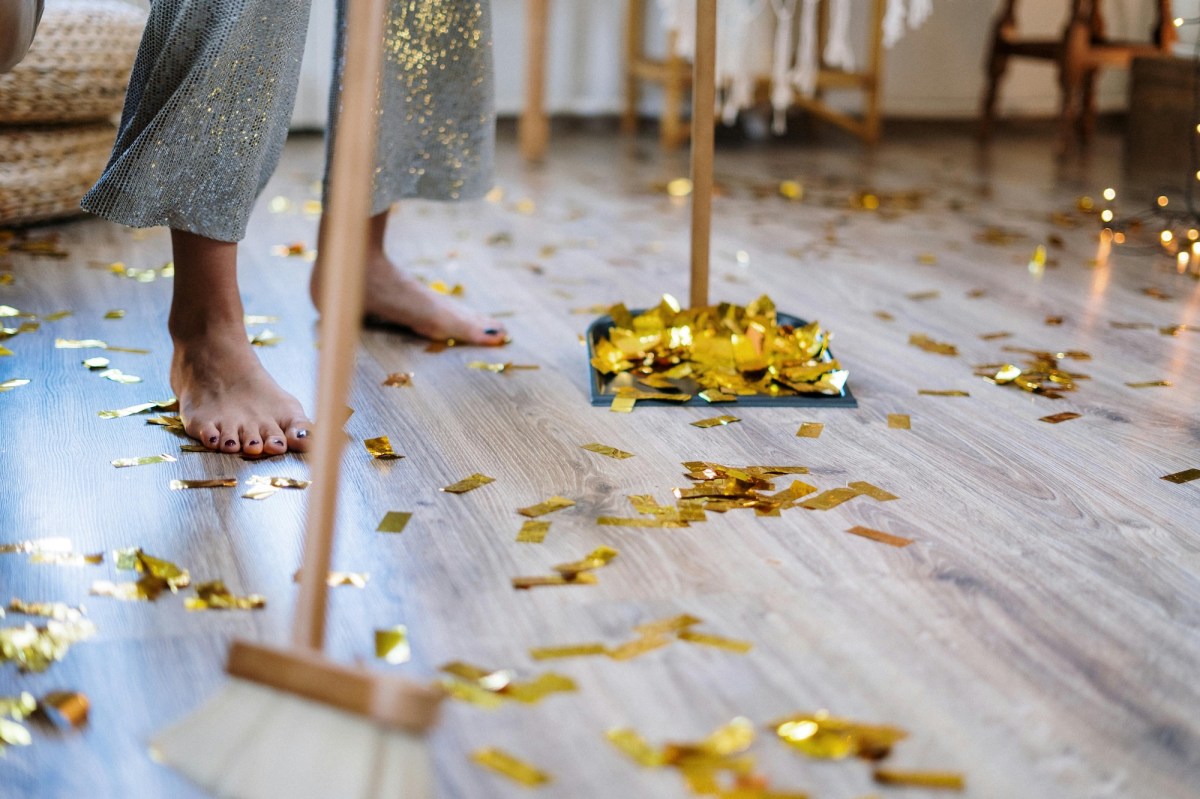 Image of woman's feet sweeping up gold streamers from celebration. Views on 2025