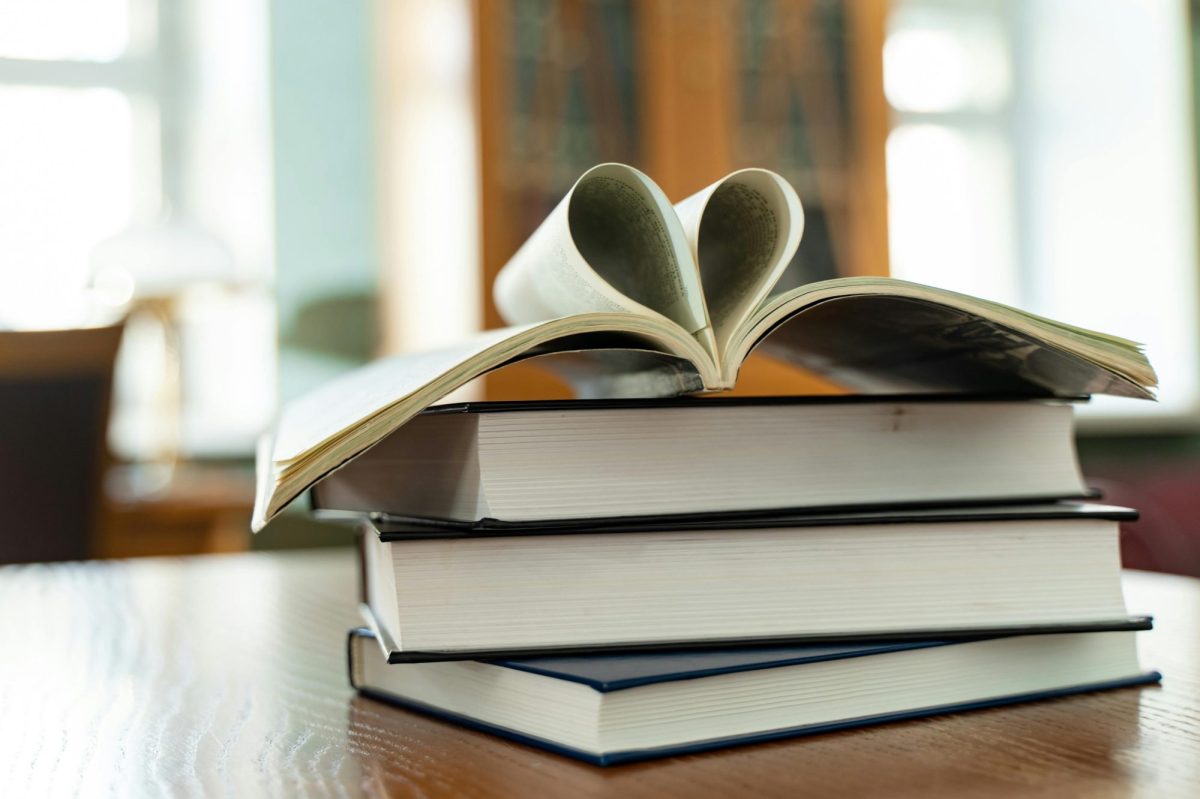 Four books in a pile; the topmost book is open, with two pages bent together to form the shape of a love heart. Indie Book Awards 2026, indie book awards