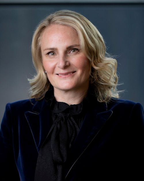 Elisa Clements joins the ACCA Board. A blonde-haired, fair-skinned woman in a blue velvet jacket and black blouse smiles at the camera.