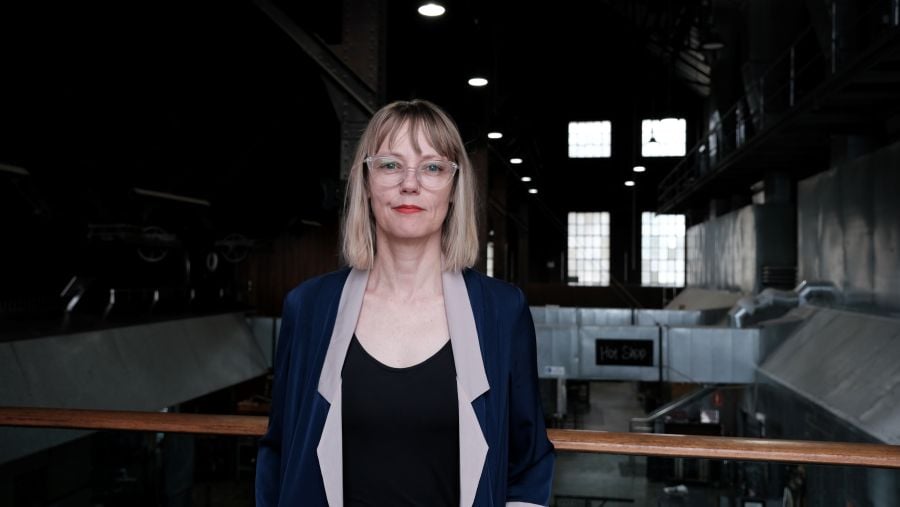 Canberra Glassworks Artistic Director CEO Aimee Frodsham. A fair-skinned woman with blonde hair and glasses smiling at the camera.